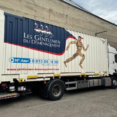 Camion de déménagement avec le logo Les Gentlemen du Déménagement sur le côté.